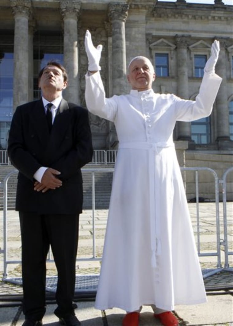 Two men dressed as Adolf Hitler, left, and the Pope, right, protest in front of the German Parliament, the  Reichstag,  against the Pope's upcoming visit in Berlin, Germany, Wednesday, Sept. 21, 2011. The two men were arrested by the police. Pope Benedict XVI will be on a four-day official visit to  Germany from  Thursday, Sept. 22, 2011. (AP Photo)